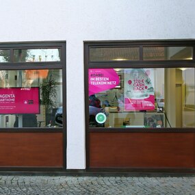 Telekom Shop mit Plakaten zu Magenta SmartHome, Cashback Aktion und 5G im Schaufenster.